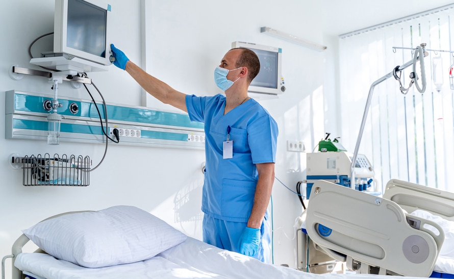 Doctor adjusting medical equipment in hospital room
