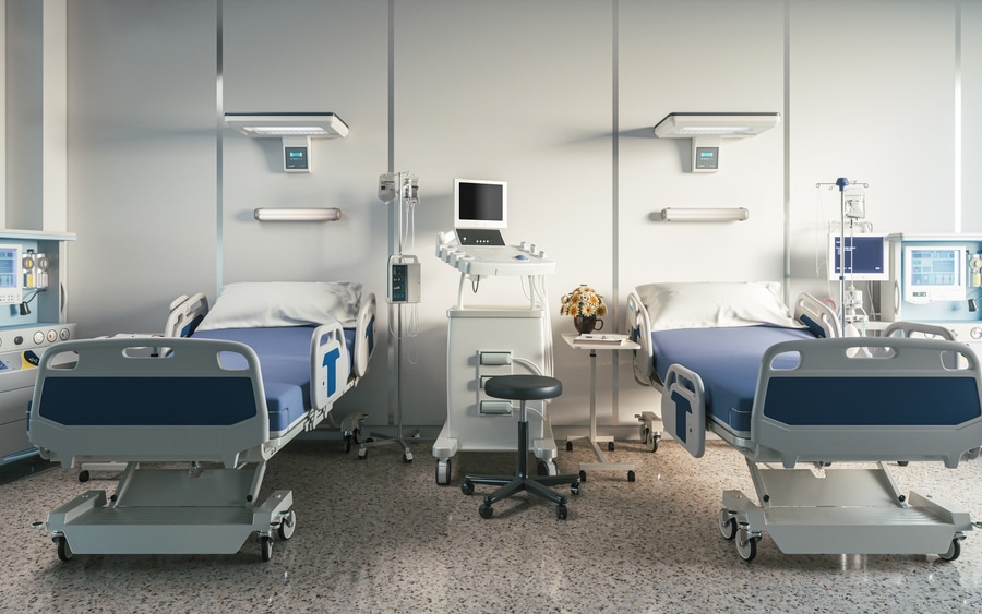 empty hospital beds in room with medical equipment