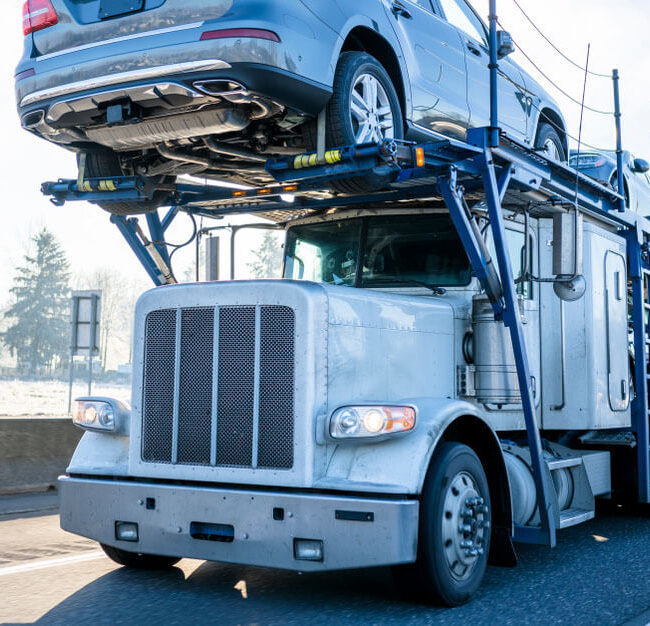Big rig semi truck on highway transporting vehicles