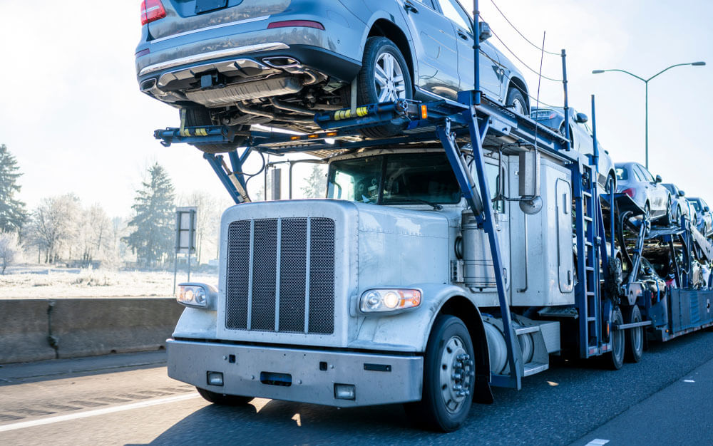 Big rig semi truck on highway transporting vehicles