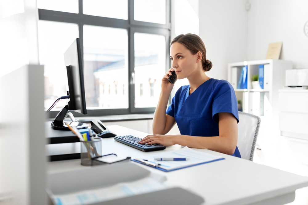 healthcare worker on phone and desk