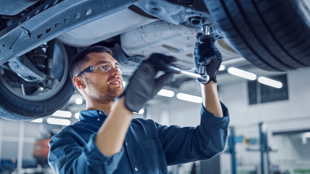 Mechanic working on vehicle as part of quality hold process