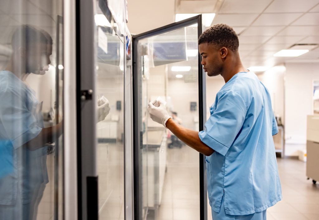 Hospital employee pulling medication from a fridge