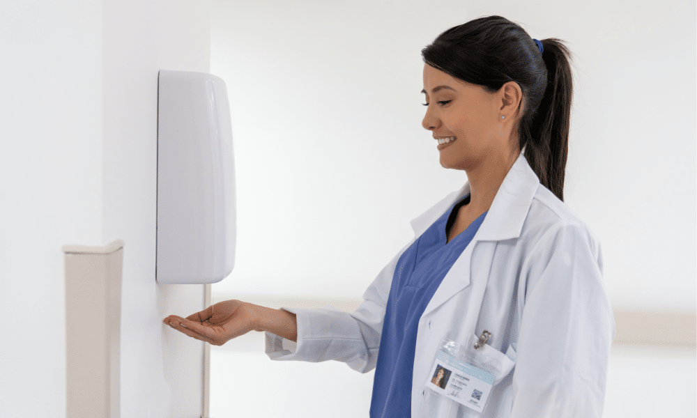 Nurse at hand sanitizer washing her hands